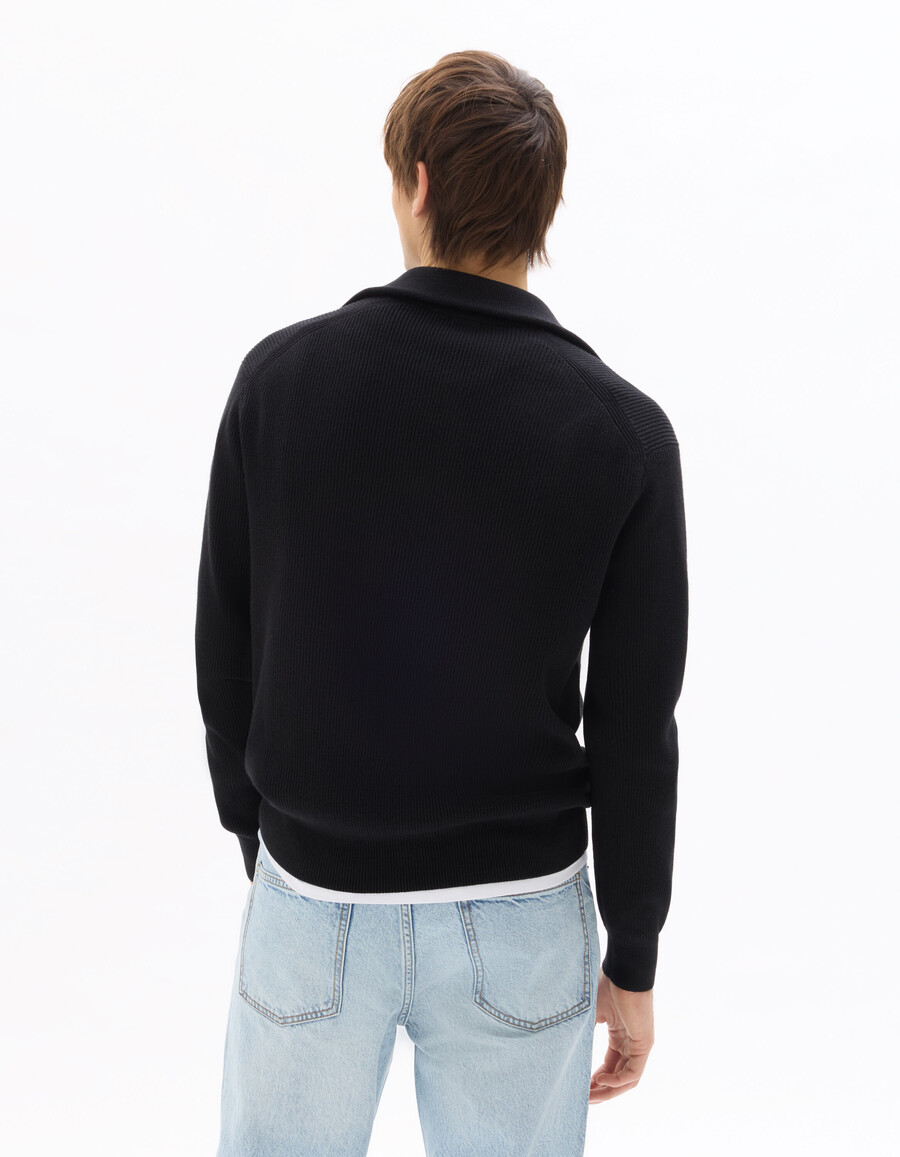 suéter negro de canalé con cuello alto y cremallera