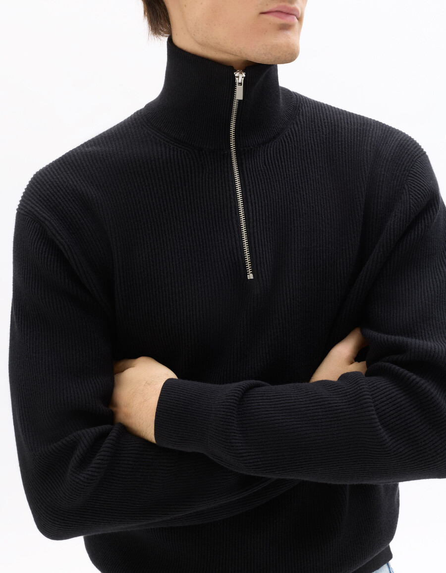 suéter negro de canalé con cuello alto y cremallera